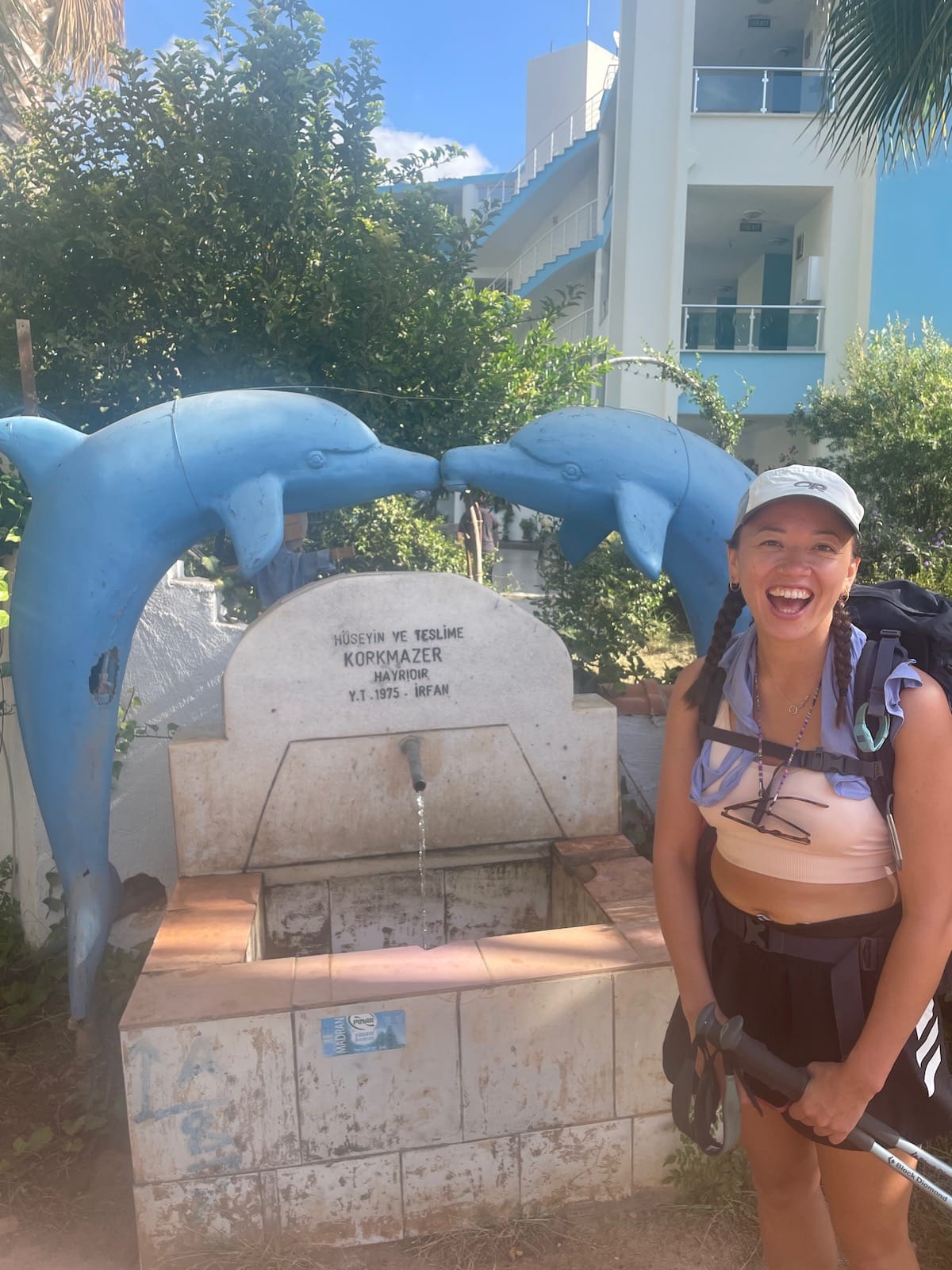 Hiker at the 'kissing dolphins' water fountain in Adrasan.